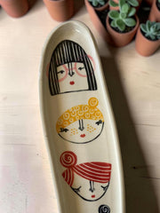 Vassoio allungato in gres multicolore con volti femminili dipinti a mano, lunghezza circa 30cm; larghezza circa 10cm