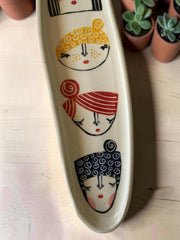 Vassoio allungato in gres multicolore con volti femminili dipinti a mano, lunghezza circa 30cm; larghezza circa 10cm